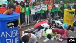 Para aktivis pecinta lingkungan di kota Surabaya melakukan aksi teatrikal dengan tema: Selamatkan Bumi dengan Kurangi Sampah Plastik dan Air Minum Kemasan (2/2).