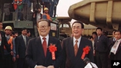 1997年11月8日，三峡工程大江截流成功，中国主席江泽民和总理李鹏（右）在三峡工程工地祝贺职工们。