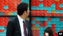 Seorang pria memperhatikan monitor yang menunjukkan Indeks Nikkei 225 di Tokyo, Jepang (foto: dok).