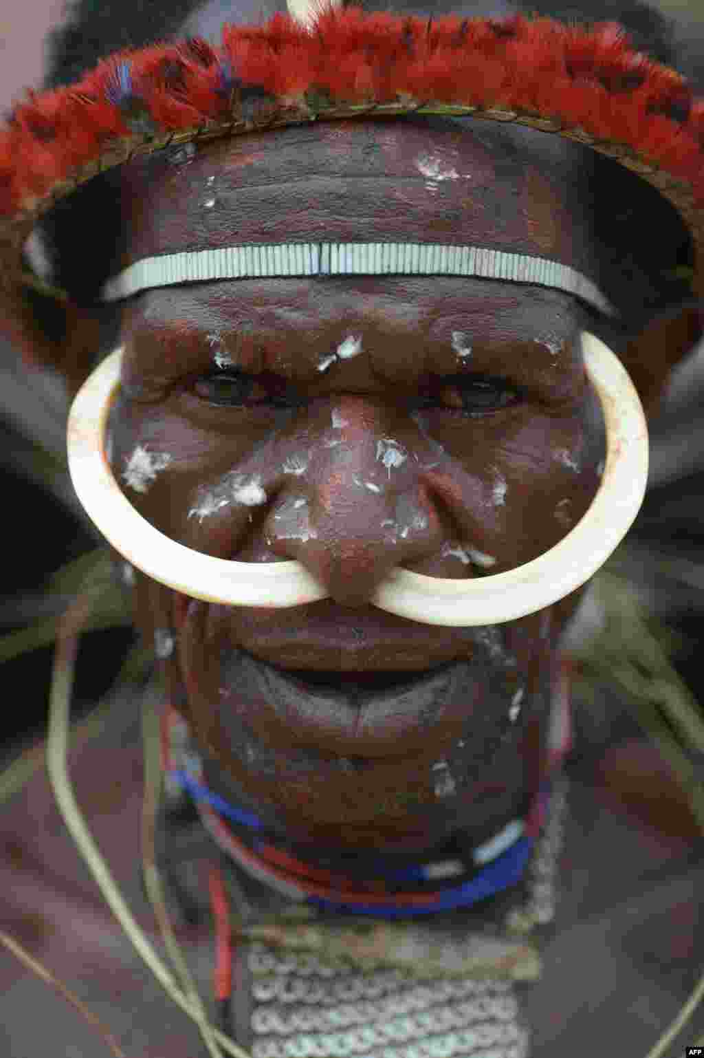 Seorang pria dari Suku Dani di Papua bersiap melakukan festival "perang-perangan" antarsuku di distrik Walesi, Wamena.