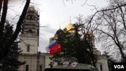 Russian political party flags and a Soviet banner fly at a war memorial in Crimea's capital, Simferopol, Ukraine, March 2, 2014. (Elizabeth Arrott/VOA)
