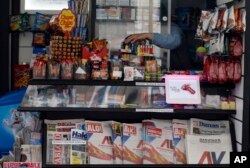 FILE - Seven major newspapers, featured at this vendor's kiosk in Belgrade, Serbia, hit the stands with the same front pages of the ruling candidate's campaign poster, March 30, 2017.