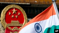 在北京人民大會堂外為來訪的印度官員舉行的歡迎儀式上，一面印度國旗在中國國徽旁飄揚（2013年10月23日）。
