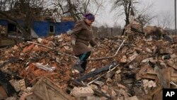 Mariya, seorang warga lokal, tampak mencari barang-barang yang masih tersisa di antara reruntuhan rumahnya yang hancur akibat pertempuran antara pasukan Rusia dan Ukraina di Desa Yasnohorodka, di pinggiran Kota Kyiv, Ukraina, pada 30 Maret 2022. (Foto: AP/Vadim Ghirda)