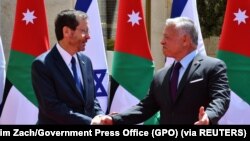 Israeli President Isaac Herzog, left, shakes hands with Jordan's King Abdullah II during a diplomatic visit to Amman, Jordan, March 30, 2022. 