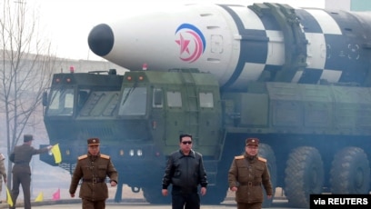 Pemimpin Korea Utara Kim Jong Un (berjaket hitam) berjalan menjauhi apa yang laporan media sebut sebagai rudal balistik antarbenua "tipe baru" dalam foto yang dirilis oleh Kantor Berita Korea Utara (KCNA) pada 24 Maret 2022. (Foto: KCNA via Reuters)