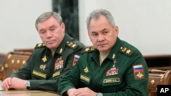资料照片：俄罗斯国防部长绍伊古(右)与俄罗斯武装部队总参谋长格拉西莫夫在莫斯科听着俄罗斯总统普京讲话。(2022年2月27日)