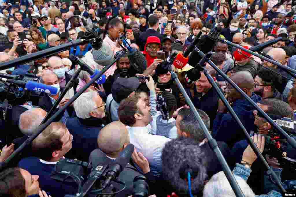 French president and candidate for the 2022 presidential election&nbsp;Emmanuel Macron carries a girl during a meeting with supporters as he campaigns in Dijon.