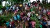 资料照片：2017年9月20日，来自缅甸若开邦的罗兴亚穆斯林难民站在斜坡上，伸出双臂接受孟加拉国考克斯巴扎尔巴鲁哈利难民营附近分发的食物。
（美联社照片）