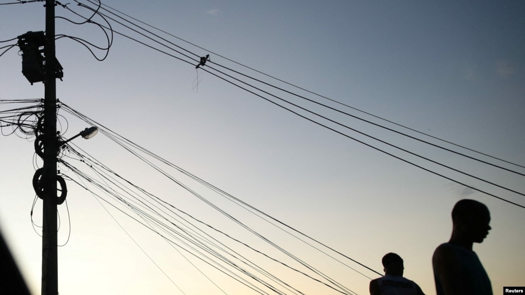 People stand near cables in a suburb of Rio de Janeiro, Brazil March 10, 2022. (REUTERS/Ricardo Moraes)