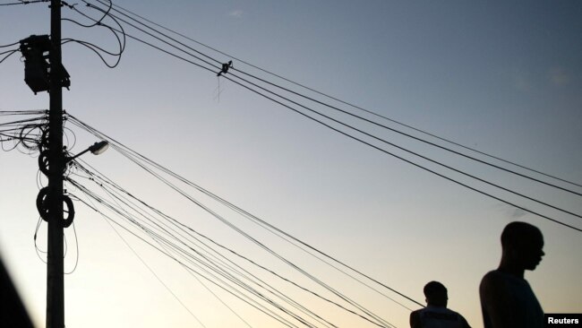 People stand near cables in a suburb of Rio de Janeiro, Brazil March 10, 2022. (REUTERS/Ricardo Moraes)