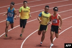Atlet asal Thailand Peerapon Watbok (kiri) berusaha mengejar lawannya Nguyen Ngoc Hiep (kanan) asal Vietnam dalam kompetisi lari 400 meter kategori T11 pada ajang Asian Para Games di Jakarta, pada 11 Oktober 2018. (Foto: AFP/Arief Bagus)