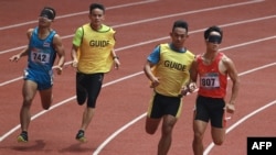 Atlet asal Thailand Peerapon Watbok (kiri) berusaha mengejar lawannya Nguyen Ngoc Hiep (kanan) dari Vietnam dalam kompetisi lari 400 meter kategori T11 pada ajang Asian Para Games di Jakarta, pada 11 Oktober 2018. (Foto: AFP/Arief Bagus)