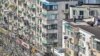 Residents stand on the rooftop of a building during the second stage of a Covid-19 lockdown in the Jing'an district in Shanghai on April 3, 2022.