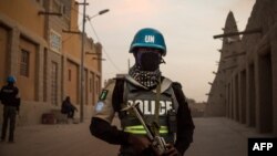 FILE - Policemen of the United Nations Stabilization Mission in Mali (MINUSMA) patrol in front of the Great Mosque in Timbuktu, Mali, Dec. 8, 2021.