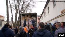 Local volunteers crowded around a truck delivering humanitarian aid sent by churches in Sicily. They quickly unloaded the packed truck to get the contents ready for distribution. (Jamie Dettmer/VOA)