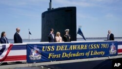 President Joe Biden returns a salute as he stands with first lady Jill Biden and Cmdr. Matthew Horton, Commanding Officer, USS Delaware, before they board the USS Delaware, at the Port of Wilmington, in Wilmington, Delaware, April 2, 2022.