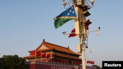 2019年10月7日，北京天安门广场，悬挂在灯柱上的中国和所罗门群岛两国国旗。 -资料图