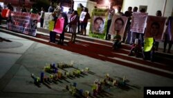 FILE - People hold pictures of the 43 missing students of the Ayotzinapa Teacher Training College Raul Isidro Burgos, during a demonstration in Tixtla, on the outskirts of Chilpancingo, in the Mexican state of Guerrero, Dec. 7, 2014.