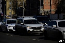 FILE - Cars, including a Russian-made Lada , center, move on a street in Moscow, March 10, 2022.