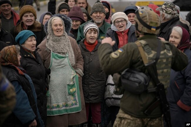 Thường dân hân hoan chào đón khi một đoàn xe quân sự và xe viện trợ của quân đội Ukraine đến Bucha, vùng ngoại ô Kyiv mà Nga từng chiếm đóng, ở Ukraine, ngày 2 tháng 4 năm 2022.
