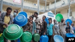 FILE - Refugees line up to receive food aid. 