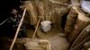 Di lembah Mes Aynak, selatan Kabul, Afghanistan, seorang arkeolog Afghanistan berdiri di samping sisa-sisa patung Buddha yang ditemukan di dalam sebuah kuil kuno, 12 Oktober 2010. (Foto: AP)