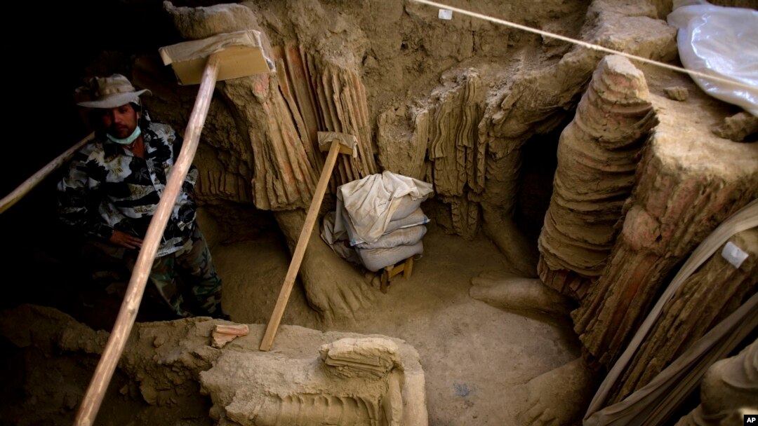 Di lembah Mes Aynak, selatan Kabul, Afghanistan, seorang arkeolog Afghanistan berdiri di samping sisa-sisa patung Buddha yang ditemukan di dalam sebuah kuil kuno, 12 Oktober 2010. (Foto: AP)