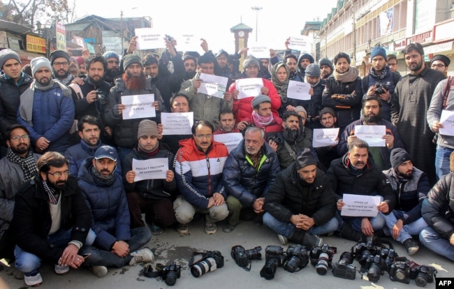 FILE - Kashmiri journalists hold placards during a march protesting media restrictions, in Srinagar, Jan. 26, 2019.