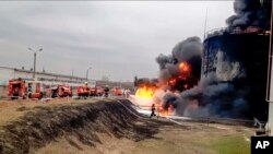 In this handout photo released by the Russian Emergency Ministry Press Service April 1, 2022, firefighters work at the site of fire at an oil depot in Belgorod, Russia.