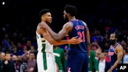 Giannis Antetokounmpo des Milwaukee Bucks, à gauche, et Joel Embiid des Philadelphia 76ers discutent pendant les dernières secondes d'un match de NBA, le mardi 29 mars 2022, à Philadelphie.