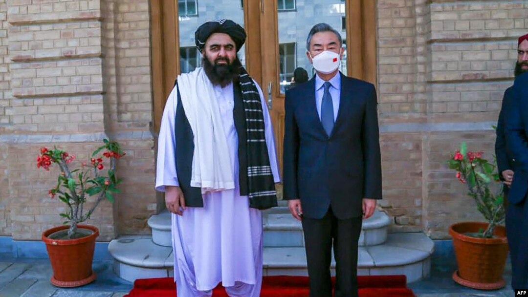 This handout photo released by the Taliban Foreign Ministry shows Taliban Foreign Minister Amir Khan Muttaqi, left, posing with China's Foreign Minister Wang Yi in Kabul on March 24, 2022.