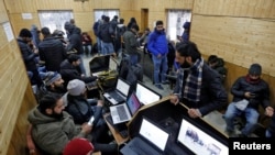 FILE - Journalists use the internet as they work inside a government-run media center in Srinagar, Jan. 10, 2020.