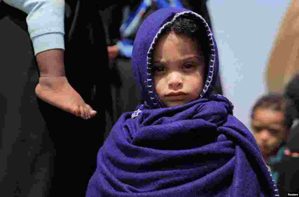 A repatriated child from Saudi Arabia waits to get registered after disembarking from a Saudi Airlines plane at the Bole International Airport in Addis Ababa, Ethiopia.