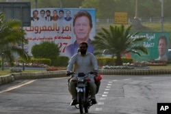 Billboard show pictures of of Pakistan's Prime Minister Imran Khan near the National Assembly, in Islamabad, Pakistan, March 28, 2022.