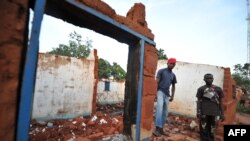 FILE - Members of the anti-Balaka Christian militia stand on March 4, 2014, in the rubbles of the house of one of their leaders destroyed by ex-Seleka rebels in Boali, near Bangui. 