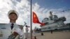 中国航母山东号停泊在海南省的一个海军基地，士兵在举行升旗仪式。（2019年12月17日）