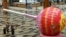 Singapore Airlines stewardesses walk past a giant lollipop candy display at Changi International Airport in Singapore as Singapore reopened its land and air borders to travelers fully vaccinated against COVID-19.
