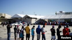 Migrantes de Haití, que regresaron al lado mexicano de la frontera para evitar la deportación, hacen cola para desayunar en un albergue del Instituto Nacional de Migración (INM) en Ciudad Acuña, México, el 25 de septiembre de 2021.