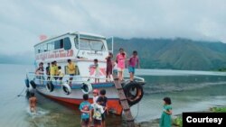 Anak-anak datang dan naik kapal belajar yang merapat di daerah Simbolon, Palipi, Samosir. (Foto: Alusi Tao Toba)