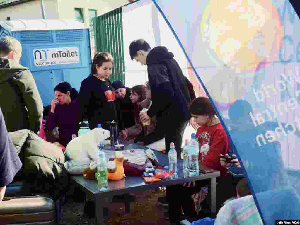 Tras llegar a Polonia, familia de refugiados descansa en uno de los puntos habilitados por voluntarios.