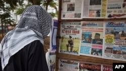 FILE - A man looks at newspaper headlines at a news stand in Bamako, Mali, June 11, 2021.