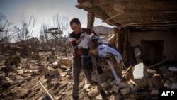 Muškarac uzima odjeću iz uništene kuće u gradu Žitomiru, na sjeveru Ukrajine, 23. marta 2022. 
