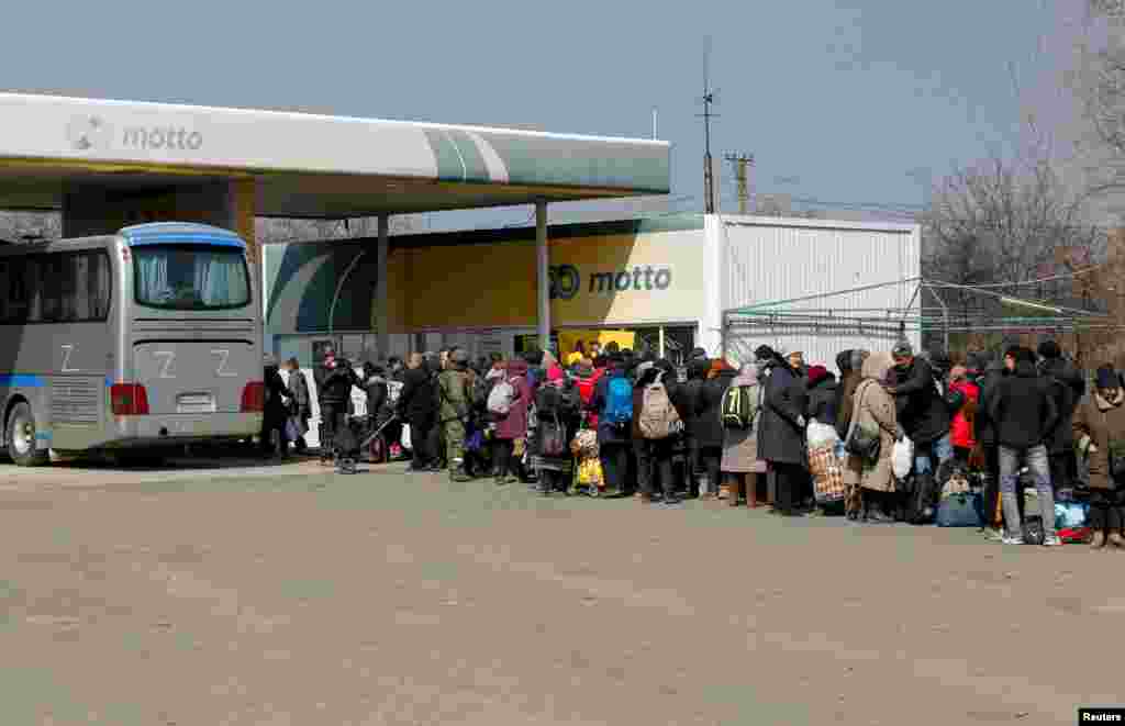 Evacuados hacen fila antes de abordar un autobús para salir de la ciudad en el curso del conflicto entre Ucrania y Rusia en el asediado puerto sur de Mariúpol, Ucrania, el 24 de marzo de 2022.