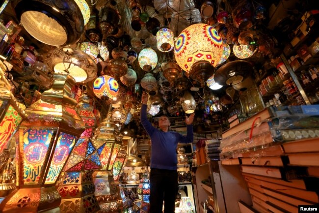 Seorang pedagang menata lentera dekoratif jelang bulan suci Ramadan di Kota Tua Yerusalem, 31 Maret 2022. (REUTERS/Ammar Awad)