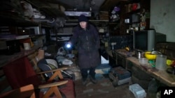 A woman shows a shelter in her basement where she and her neighbors have been living for a month, hiding from the Russian shelling in Kharkiv, Ukraine, March 26, 2022.