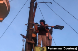 Mahasiswa Teknik Sipil Universitas Pertamina memasang panel surya di Dusun Kuri Caddi, Kecamatan Marusu, Sulawesi Selatan. (Foto: Pertamina)