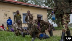 Des membres du groupe rebelle M23 de la République démocratique du Congo sont assis dans le camp de réfugiés de Ramwanja le 17 décembre 2014.
