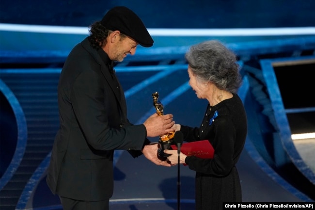 Youn Yuh-jung, right, presents Troy Kotsur with the award for best performance by an actor in a supporting role for "CODA" at the Oscars on Sunday, March 27, 2022, at the Dolby Theatre in Los Angeles.