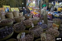 Seorang pedagang Mesir menjual kurma dan buah-buahan kering di pasar tradisional di distrik Central Sayyida Zeinab, Kairo, pada 30 Maret 2022. (Foto: AFP)